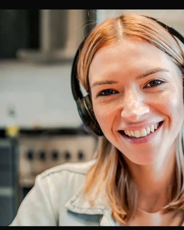 A smiling person wearing headphones