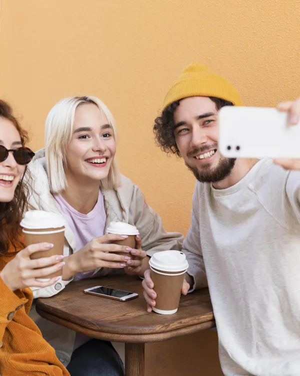 Three friends taking a selfie at a café